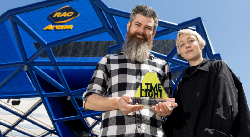 Two members of Alter Boy, Josh and Molly, standing out the front of RAC Arena holding their Limelight trophy.