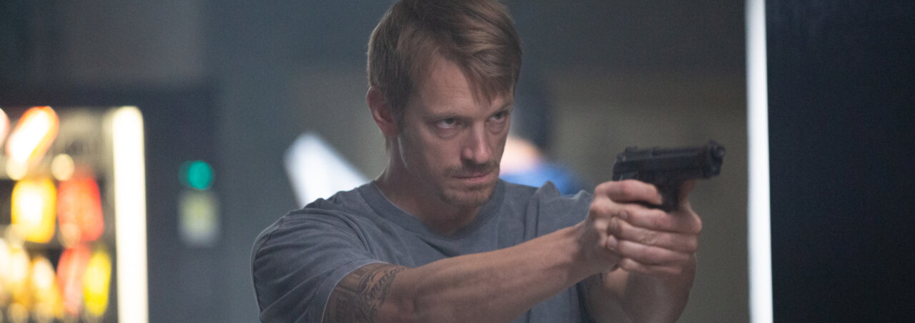 A shot from the movie Silent Night featuring a man pointing a gun at something