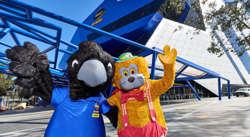 Fat Cat with RAC Arena's mascot, Banks, standing in front of the venue.