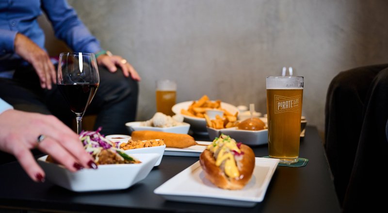 Various items of food and glasses of beer and wine on a table in Pirate Life Bar