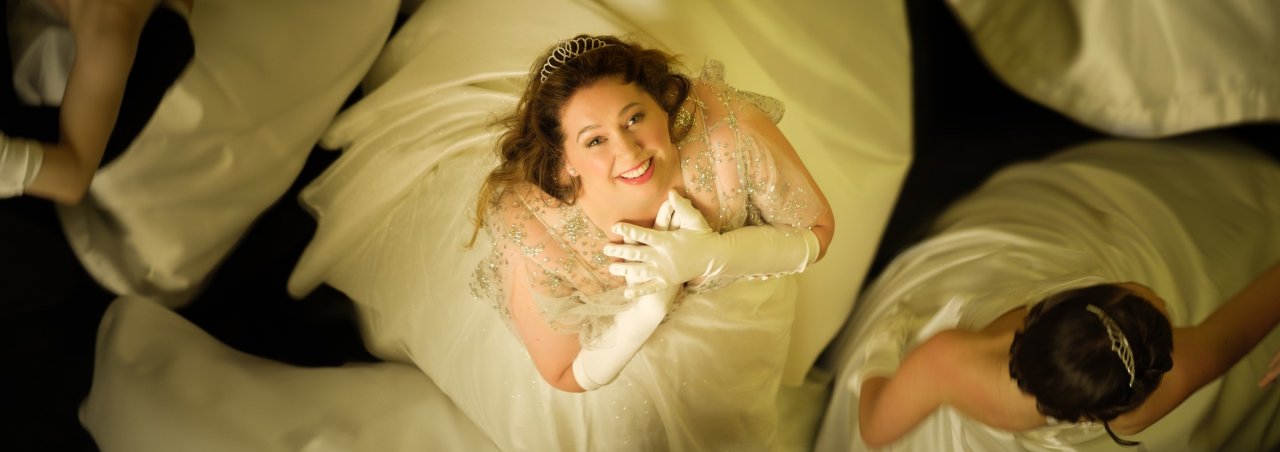 View from above of character, Taylah Simpkins, wearing a white dress and gloves