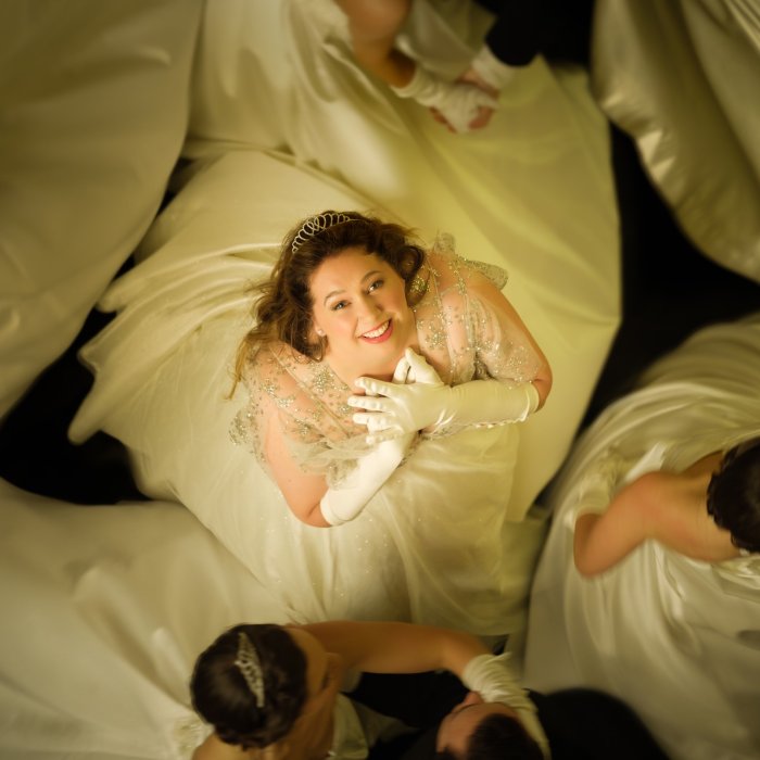 View from above of character, Taylah Simpkins, wearing a white dress and gloves